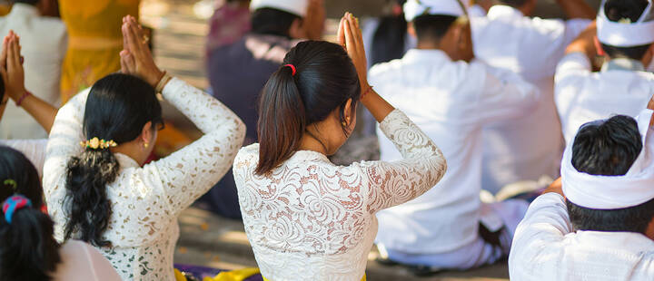 Young Balinese women praying in a temple 