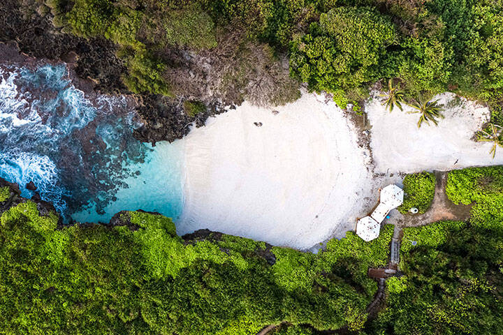 Aerial view of secluded beach, with white sand and clear turquoise water