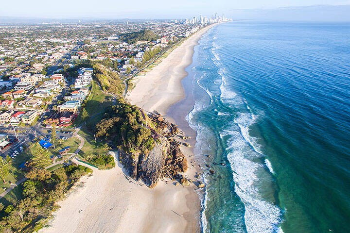 Aerial view of Miami Headland and beach as the sunrise glow hits the foreshore. Gold Coast, Australia