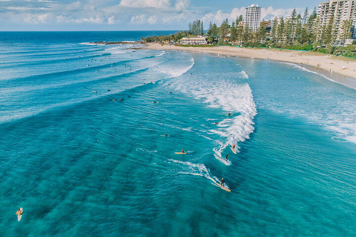 An aerial view of surfers and swimmers at Rainbow Bay, Gold Coast, Australia