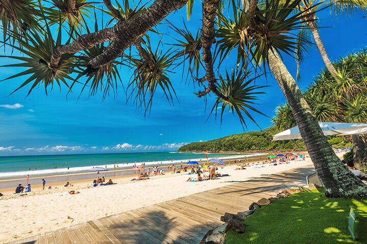 People enjoying summer at Noosa main beach - a famous tourist destination in Queensland 