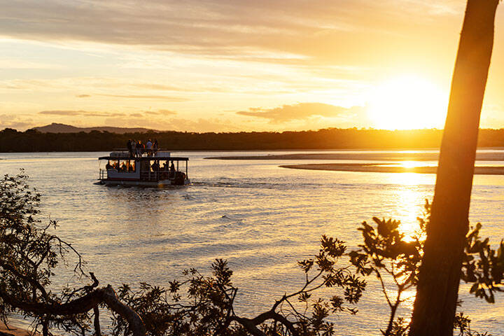 Tourist Boat whit Group of People in the Sea at Sunset Time in Noosa, Queensland, Australia. 