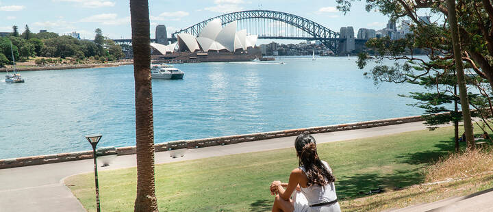 Woman in Sydney, looking at the view of Sydney Opera House & Harbour Bridge.