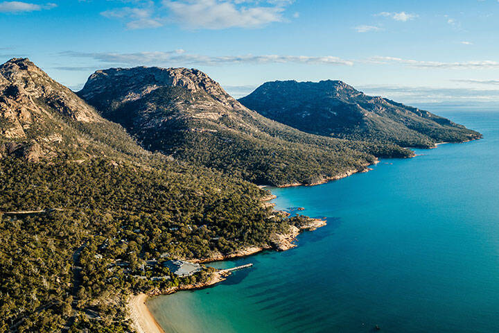Mountains, forest and clear blue waters on the coast o Freycinet National Park