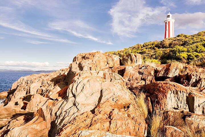 Mersey Bluff Lighthouse in Devonport, Tasmania standing above lichen covered rocks.