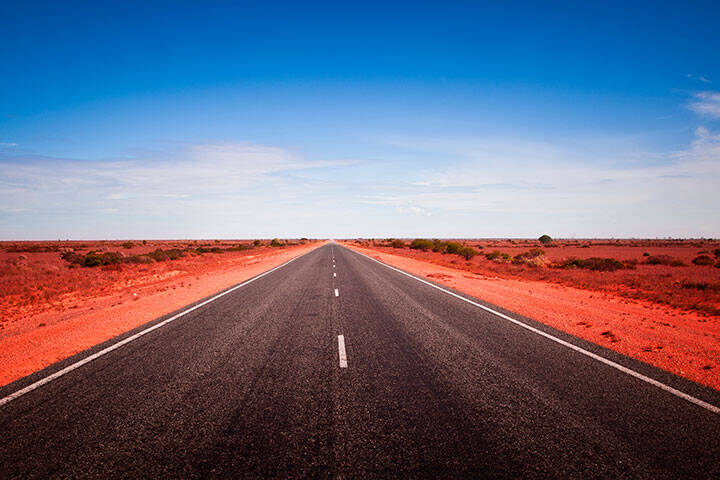 90 Mile Straight. Australia's longest straight road. Open road crossing the Nullarbor Plain in Western Australia. Long road stretching into the distance. Adventure Travel.