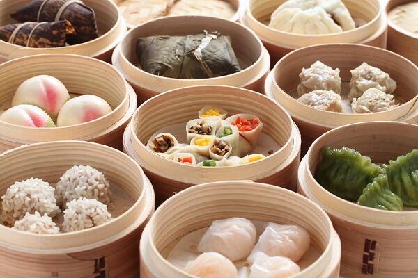 Steamed baskets filled with prawn, vegetable, and siu mai dumplings at Yum Cha in Sydney, showcasing a variety of delicious dim sum.