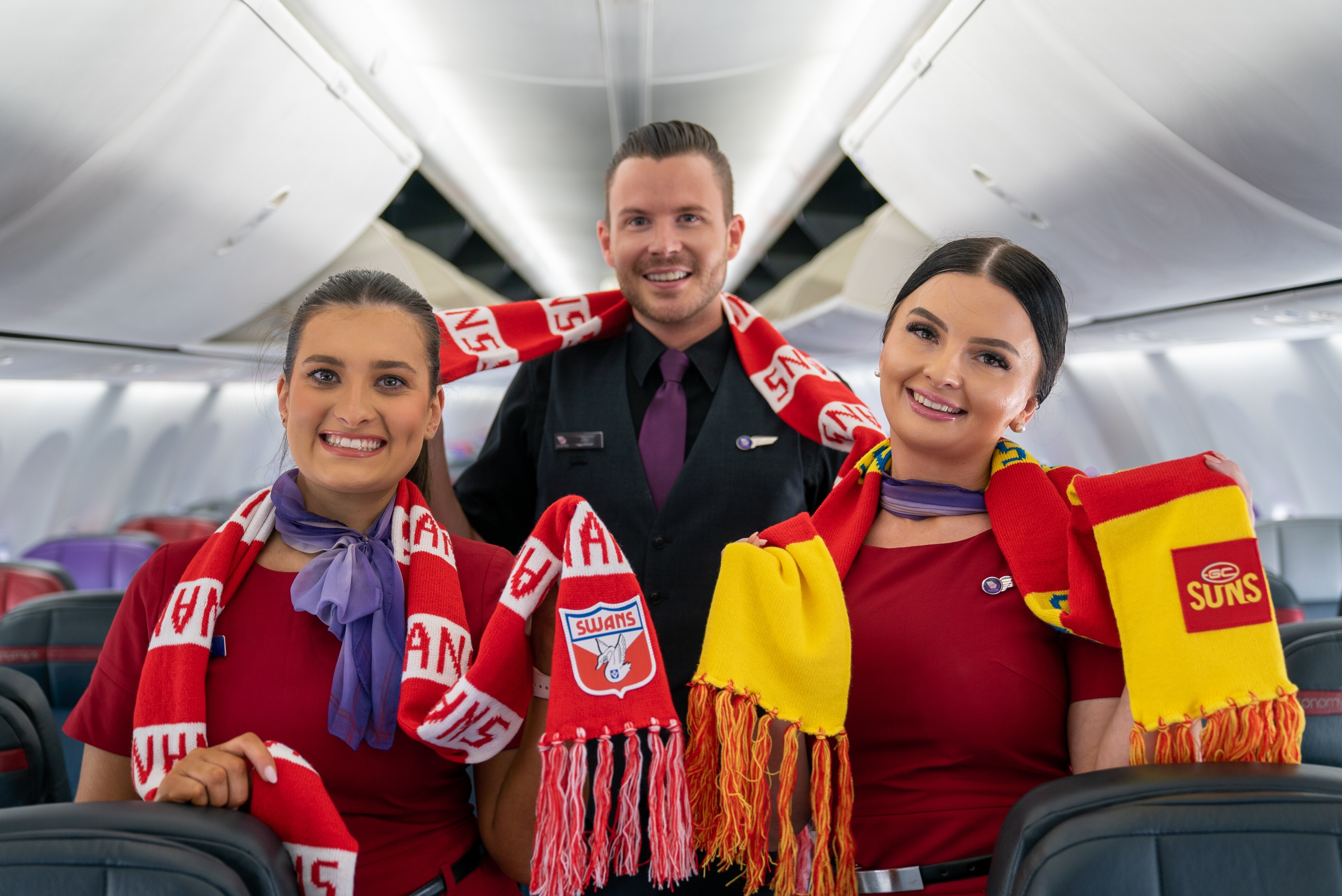 Virgin Australia cabin crew wearing AFL merchandise in the cabin, showing support for their sports teams.