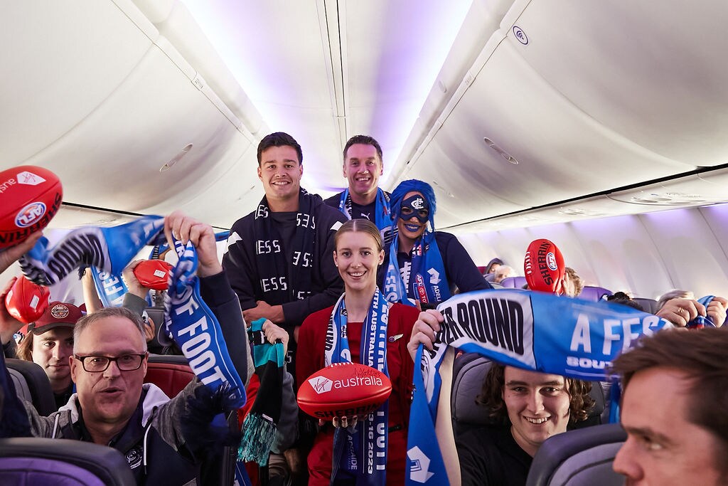 Passengers wearing Carlton Football Club merchandise on a Virgin Australia flight
