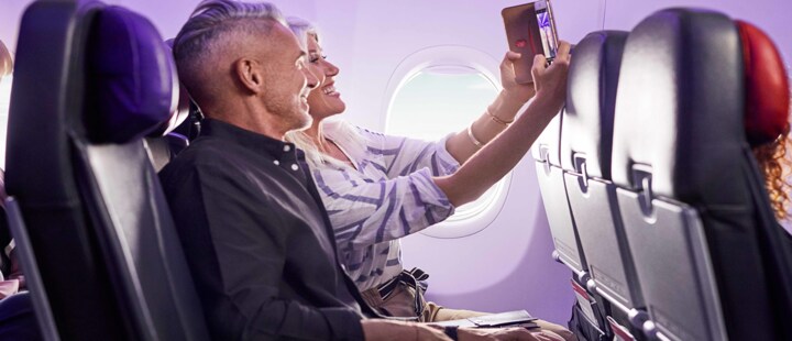 Couple sitting in economy cabin on board Virgin Australia flight