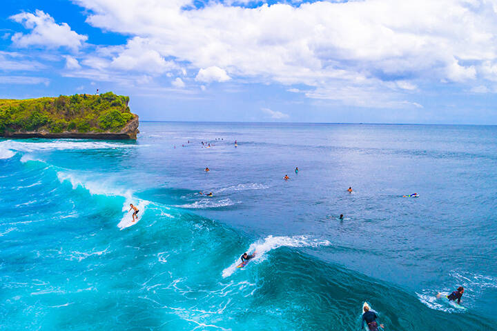 Surfers riding waves at Balangan Beach, Bali