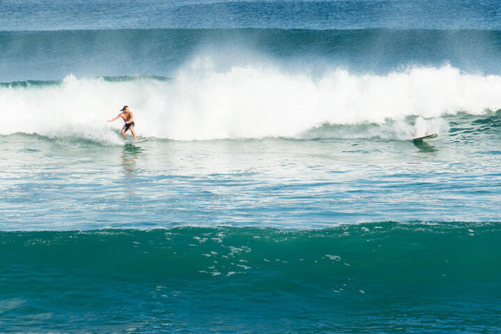 Surfer riding waves at Dreamland Beach, Bali