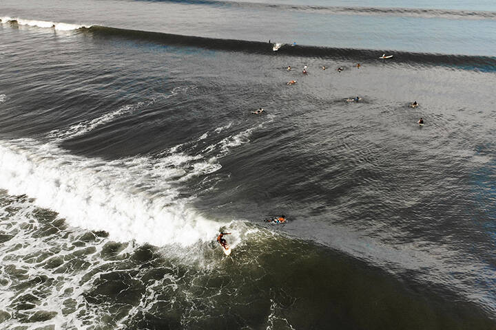 A local surfer trims down the line of an open wave at Medewi, Bali