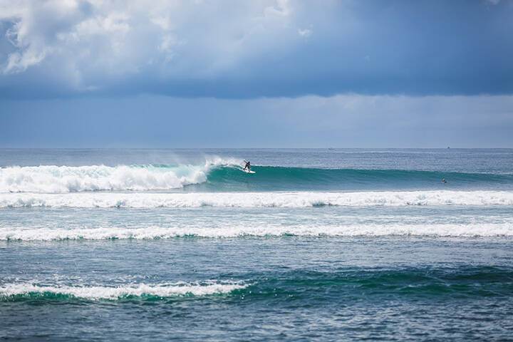Surfer riding a wave in Serangan, Bali