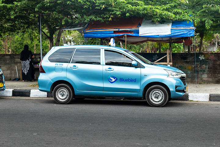 Bluebird group taxi on the street in Indonesia. Blue Bird taxi is famous for its reliability in Indonesia