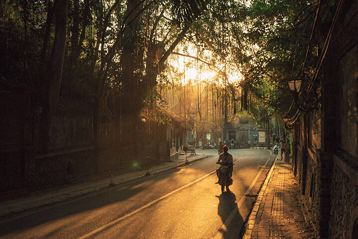 Person riding on motorcycle in Ubud at sunset